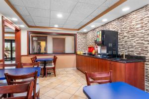 Un restaurante con mesas y sillas y un televisor. en Econo Lodge Woodbridge, en Iselin