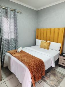 a bedroom with a bed with a yellow headboard at Ogans guest villa 20 Johan Meyer St, Linmeyer, Johannesburg in Johannesburg +102 photos