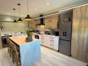 a kitchen with a table and a stainless steel refrigerator at 20 At Jeanette in Windhoek