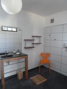 La salle de bains est pourvue d'un lavabo et d'une chaise orange. dans l'établissement Gite Carpe Diem, à Port-de-Lanne