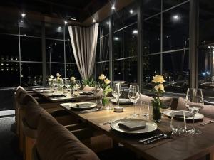 ein langer Tisch mit Stühlen und Gläsern und ein großes Fenster in der Unterkunft Transit Samui Resort in Koh Samui 