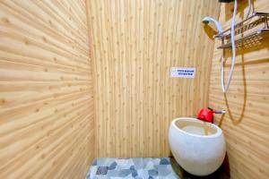 a bathroom with a toilet in a wooden wall at Embun Lawu Cottage Tawangmangu in Sarangan +48 photos