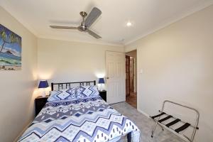 a bedroom with a bed and a dresser at Golden Cane Bed & Breakfast in Bargara