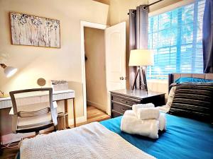 a bedroom with a bed and a desk and a window at Near the Strip, Smart TVs, WiFi, private garage and backyard in Las Vegas