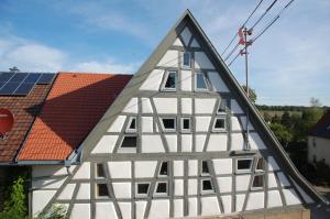 ein Fachwerkhaus mit einem Dach mit Sonnenkollektoren in der Unterkunft Carles Scheunenhof in Zweiflingen