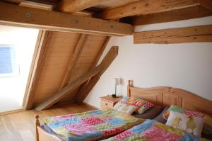 um quarto com uma cama num quarto com tectos em madeira em Carles Scheunenhof em Zweiflingen