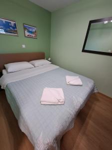 a bedroom with a bed with two towels on it at Little House Ligia in Lygia