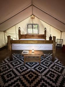 a room with a bed and a table in a tent at Rustic Safari Tent for a Unique Glamping Experience near Gore Mountain, New York in North Creek