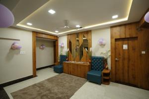 un vestíbulo con una sala de espera con sillas azules en Hotel Deol's Paradise, en Indore