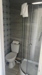 een badkamer met toilet en glazen douche bij Flamingo Short Lets 4 Bed 4 Bath House Neath Hill in Great Linford