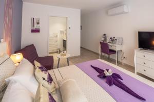 a bedroom with a large bed with a purple towel on it at "Notre Bastide" Maison et table d'hôtes à réserver 48 h avant, Piscine, jacuzzi, Climatisation, , à 5 mn de SARLAT in Marcillac-Saint-Quentin