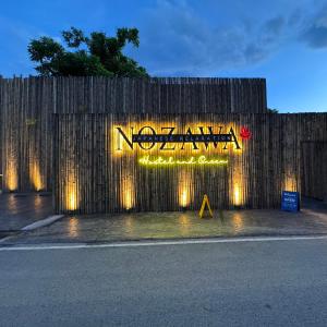 un cartello su una recinzione con luci sopra di Nozawa Hostel and Onsen - Men Only a Chiang Mai