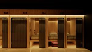 uno spogliatoio con quattro porte e alcuni letti di Nozawa Hostel and Onsen - Men Only a Chiang Mai Altre 28 foto