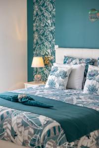 a bedroom with a bed with a blue wall at "Notre Bastide" Maison et table d'hôtes à réserver 48 h avant, Piscine, jacuzzi, Climatisation, , à 5 mn de SARLAT in Marcillac-Saint-Quentin +53 photos