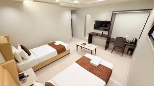 a hotel room with two beds and a flat screen tv at Hotel Nova Vista in Rajkot +28 photos