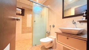 a bathroom with a sink and a toilet and a shower at Hotel Nova Vista in Rajkot
