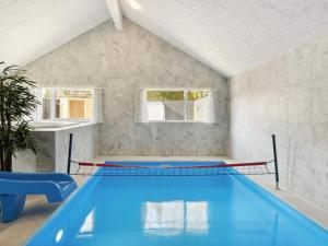 a swimming pool in a white room with a blue swimming pool at 5 star holiday home in Dronningmølle in Dronningmølle
