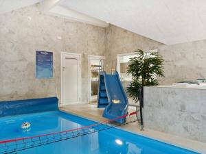 a swimming pool with a slide in a room at 5 star holiday home in Dronningmølle in Dronningmølle