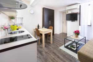 a kitchen and a living room with a table in a room at Gloria apartment Rovinj - Heart of Old town - Steps from Sea in Rovinj