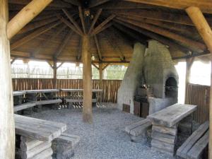 um grande pavilhão de madeira com bancos e um forno exterior em Agroturystyka "Bociek" em Bełk