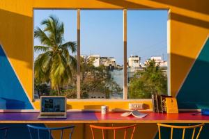 a table with a laptop on it in front of a window at goSTOPS Bengaluru, Gandhi Nagar Majestic in Bengaluru