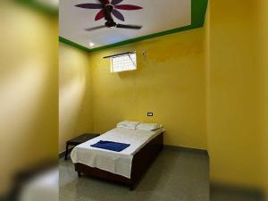 a bedroom with a bed and a ceiling fan at SPOT ON Dream Guest House in Kankather