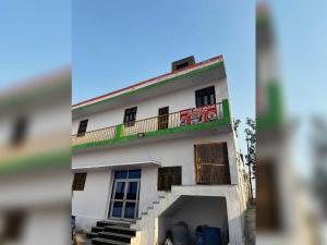 a white building with a balcony on top of it at SPOT ON Dream Guest House in Kankather