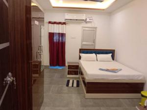 a bedroom with a bed and a red curtain at SPOT ON Khushi Lodge in Kurua