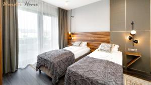 ソスノフカにあるWonder Hill - klimatyzowane apartamenty z bajkowym widokiem na góry i zalewのベッドが2つと窓があるホテルの部屋
