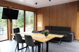 a living room with a table and a couch at Metsamajake Hubert sauna ja mullivanniga looduse keskel in Sigula