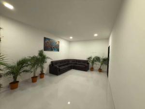 a living room with a couch and potted plants at Hotel O Fortune Palace in Hinjewadi