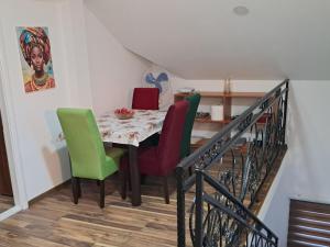 a dining room table with green and red chairs at New Modern Duplex with Free Parking in Prijepolje