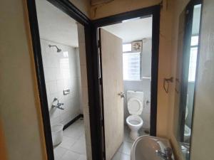 a bathroom with a toilet and a sink and a mirror at Hotel O Fortune Palace in Hinjewadi
