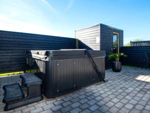 a black fence with two seats on a patio at 16 person holiday home in Sydals in Sarup