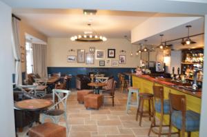 ein Restaurant mit Tischen und Stühlen und eine Bar in der Unterkunft Woolpack Pub & Kitchen in Wainfleet All Saints
