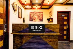 un vestíbulo del hotel con un cartel en la pared en Hotel O Kilambakkam New Bus Terminal Formerly TAD Homes, en Urapakkam
