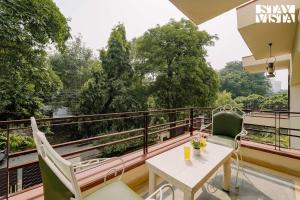 a balcony with a table and chairs and a view at StayVista at Moets Palm Villa with BBQ & Bonfire in Gurgaon