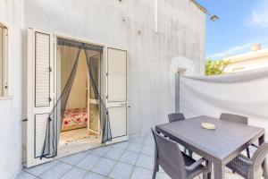 a patio with a table and chairs and a bedroom at Mauricarol Residences in Acquarica del Capo