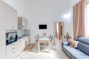 a kitchen and living room with a table and a couch at Mauricarol Residences in Acquarica del Capo
