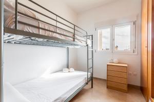 a bedroom with two bunk beds and a dresser at Viviaro Llibertat in Puerto de Sagunto