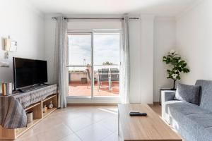 a living room with a couch and a large window at Viviaro Llibertat in Puerto de Sagunto