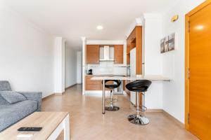 a kitchen with a couch and two bar stools at Viviaro Llibertat in Puerto de Sagunto