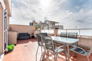 a balcony with a table and chairs on a roof at Viviaro Llibertat in Puerto de Sagunto