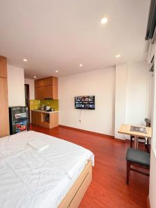 Un dormitorio con una cama grande y una cocina. en DeepHome - Trinh Cong Son, en Hanói