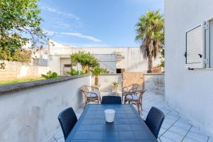 a patio with a blue table and chairs at Mauricarol Residences in Acquarica del Capo