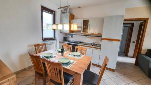 a kitchen and dining room with a wooden table and chairs at Residenza La Rocca in Castello Valsolda