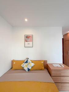 Un dormitorio con una cama con almohadas amarillas. en DeepHome - Trinh Cong Son, en Hanói