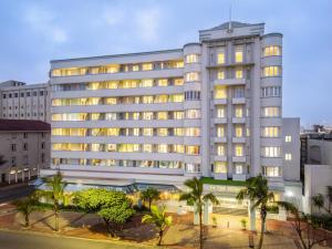 a large white building with palm trees in front of it at The Edward in Durban