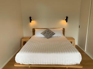 a bed in a bedroom with two pillows on it at Perch Lorne in Lorne