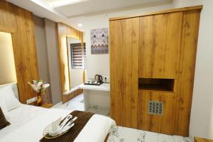 1 dormitorio con pared de madera, cama y lavamanos en Hotel Deol's Paradise, en Indore